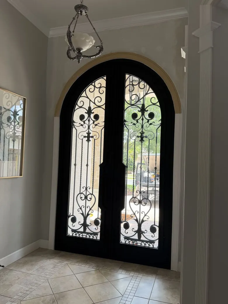 Arched iron door with fleur-de-lis scrollwork — engineering and coordination view