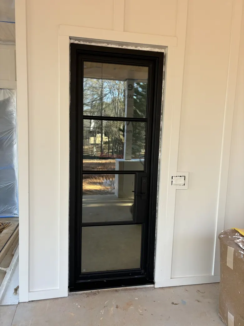 Slim black-framed glass entry with divided lites, photographed during installation — PDA Doors & More, Florida